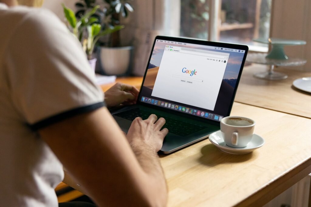 Image showing a person using a laptop with the Google website open.